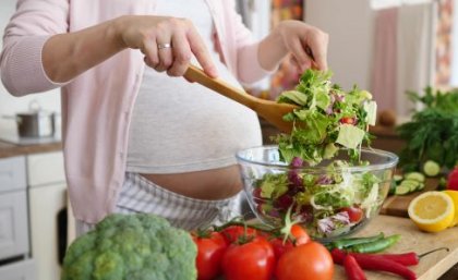 Iron deficiency affects an estimated 40 per cent of pregnant women. Image: Adobe. A pregnant woman makes a healthy salad.